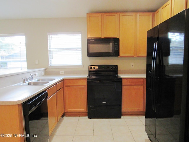 kitchen featuring black appliances, a wealth of natural light, a sink, and light countertops