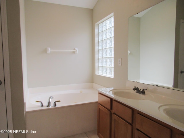 bathroom featuring plenty of natural light, double vanity, a sink, and a bath