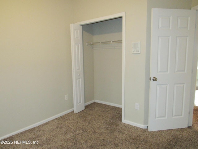 unfurnished bedroom featuring a closet, carpet flooring, and baseboards