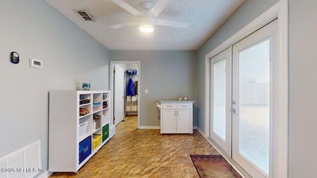 washroom featuring ceiling fan, french doors, and a textured ceiling