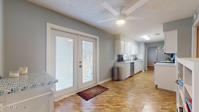 kitchen featuring ceiling fan, dishwasher, white cabinetry, a textured ceiling, and french doors