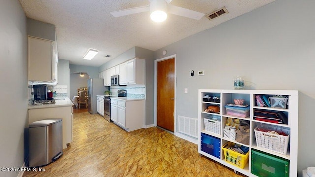 kitchen featuring white cabinetry, a textured ceiling, light hardwood / wood-style flooring, appliances with stainless steel finishes, and ceiling fan