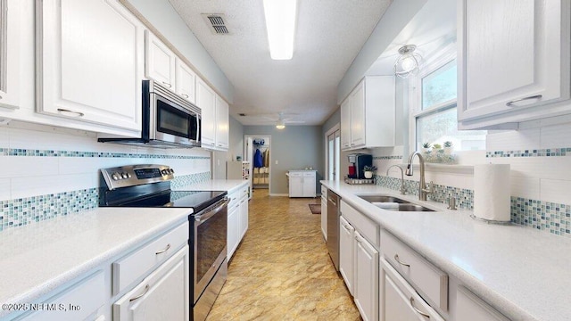 kitchen with white cabinetry, sink, backsplash, and stainless steel appliances