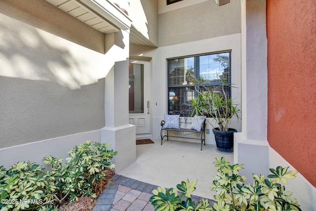 doorway to property featuring stucco siding