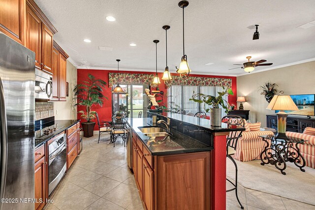 kitchen with brown cabinets, crown molding, stainless steel appliances, and a sink