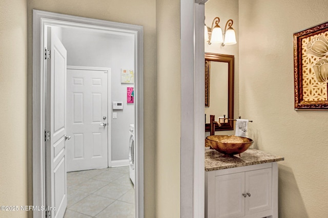 bathroom with tile patterned floors, washer / clothes dryer, and vanity