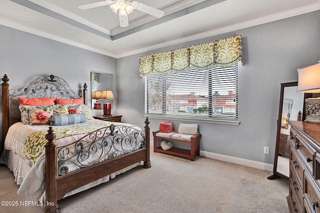 bedroom featuring ceiling fan, carpet floors, baseboards, ornamental molding, and a tray ceiling