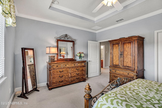 bedroom featuring light colored carpet, a ceiling fan, visible vents, ornamental molding, and a tray ceiling