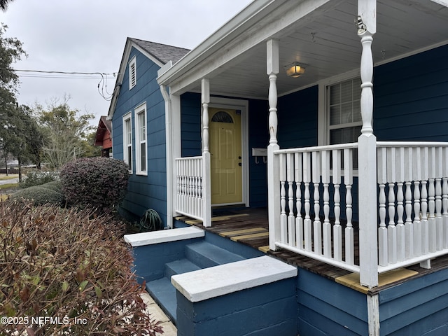 view of exterior entry featuring covered porch