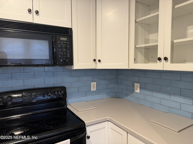 kitchen featuring decorative backsplash, white cabinets, and black appliances