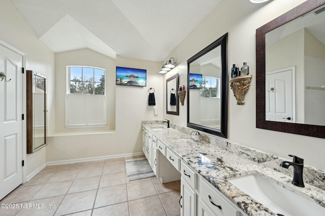 bathroom featuring tile patterned flooring, vanity, lofted ceiling, and a textured ceiling