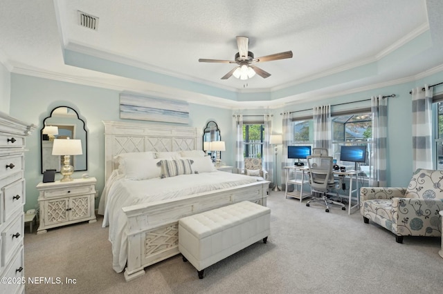 bedroom featuring a raised ceiling, light carpet, a textured ceiling, and ceiling fan