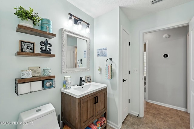 bathroom with vanity, a textured ceiling, and toilet