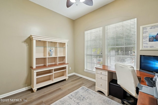 home office with light hardwood / wood-style flooring and ceiling fan