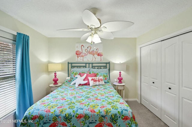 carpeted bedroom with multiple windows, ceiling fan, a closet, and a textured ceiling