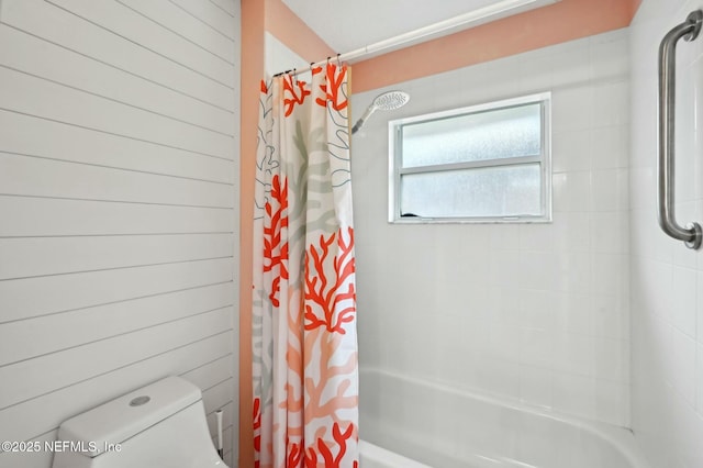 bathroom featuring shower / bath combination with curtain, wooden walls, and toilet