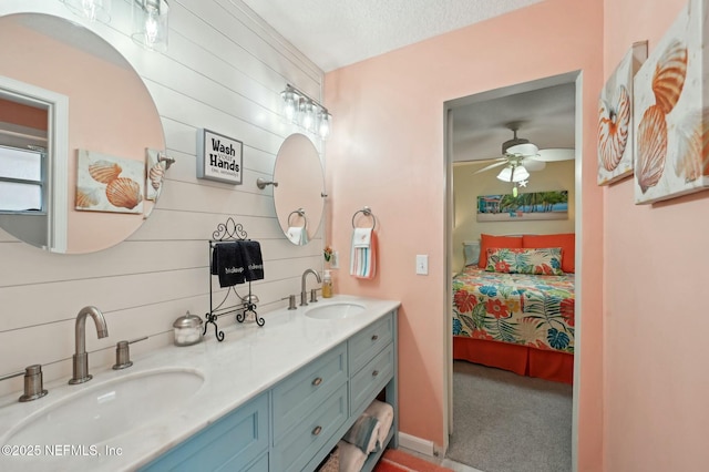 bathroom featuring ceiling fan, vanity, a textured ceiling, and wood walls