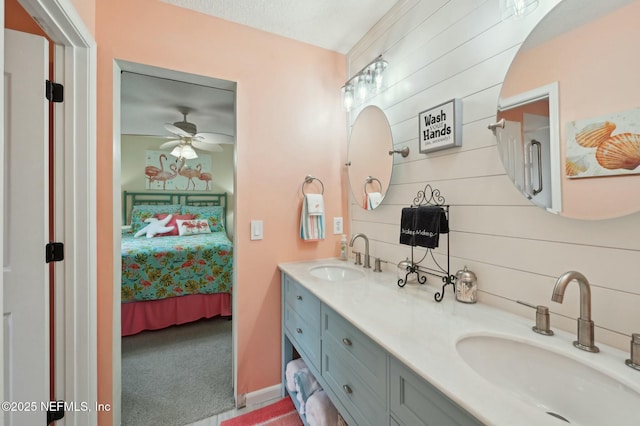 bathroom with ceiling fan, vanity, and wood walls