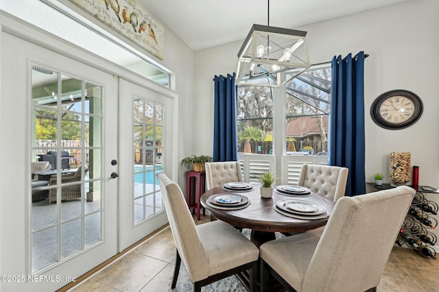 tiled dining room with french doors, a chandelier, and a wealth of natural light