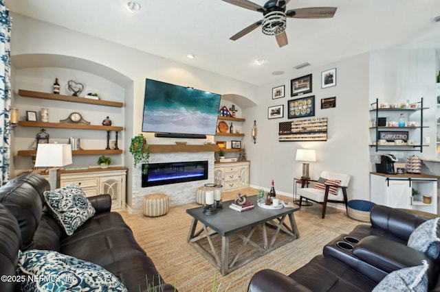 living room with ceiling fan and built in shelves