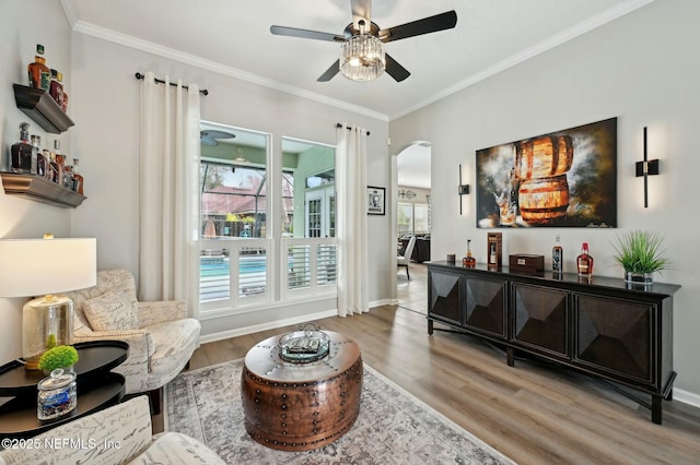 sitting room with hardwood / wood-style flooring, ceiling fan, and ornamental molding