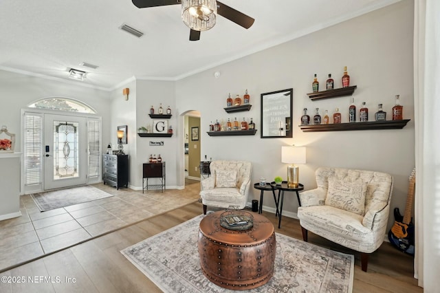 interior space featuring ceiling fan, ornamental molding, and light wood-type flooring