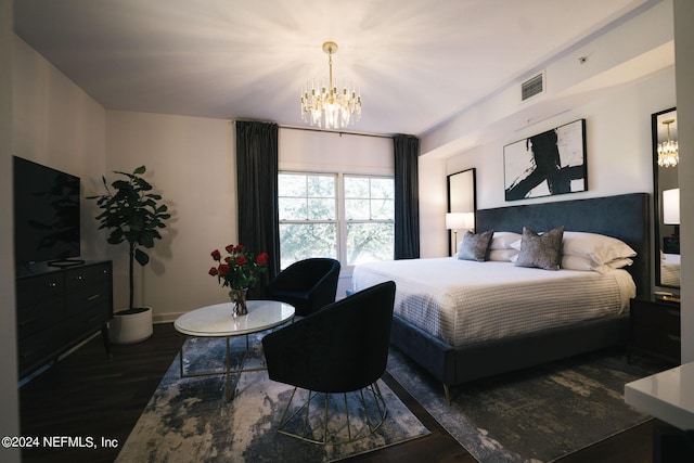 bedroom featuring dark hardwood / wood-style floors and an inviting chandelier