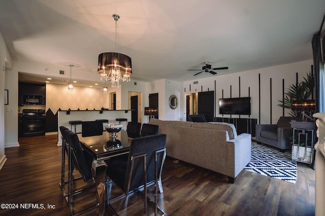 dining room with ceiling fan with notable chandelier and dark wood-type flooring