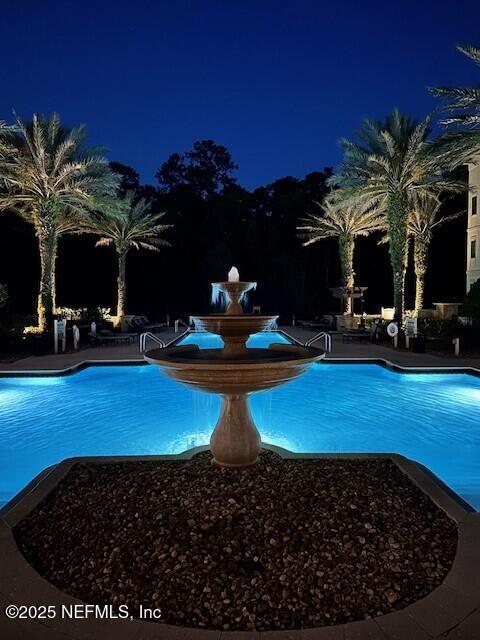 view of pool at twilight