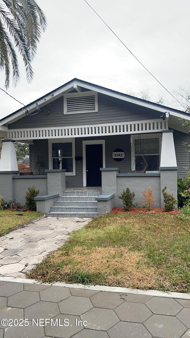 view of front of property with covered porch and a front yard