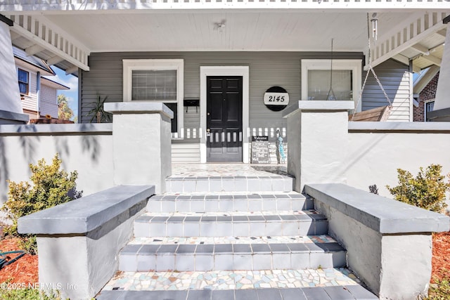 view of exterior entry featuring covered porch