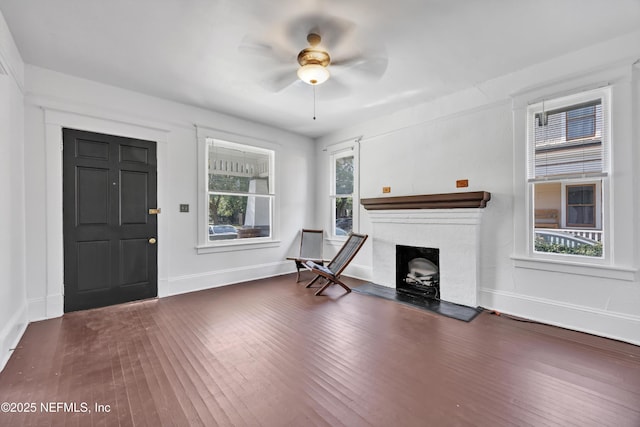 unfurnished living room with ceiling fan and dark hardwood / wood-style flooring