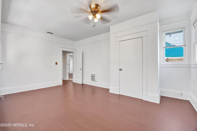 unfurnished bedroom featuring ceiling fan and dark hardwood / wood-style flooring