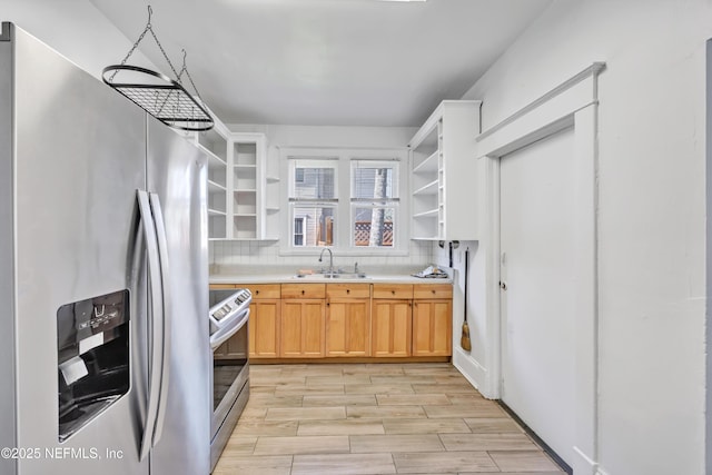 kitchen with appliances with stainless steel finishes, sink, backsplash, light hardwood / wood-style floors, and light brown cabinets