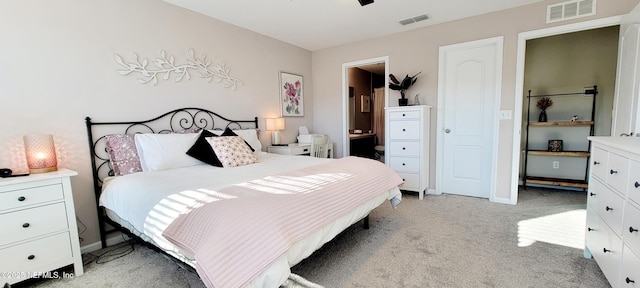 bedroom with connected bathroom and light colored carpet