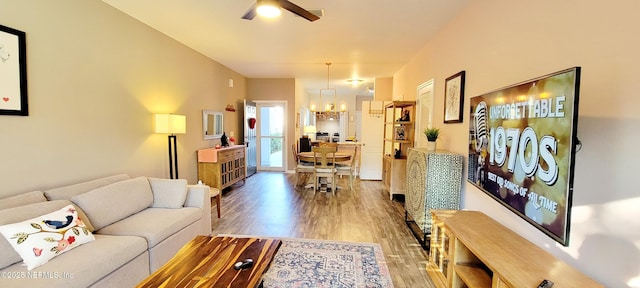 living room featuring hardwood / wood-style floors and ceiling fan with notable chandelier