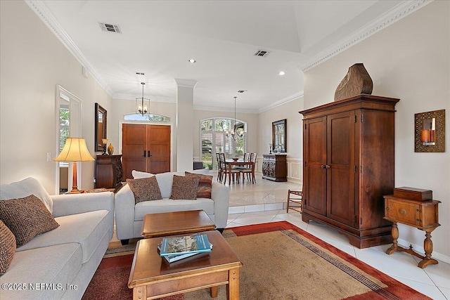 living room with a notable chandelier, ornamental molding, and light tile patterned flooring