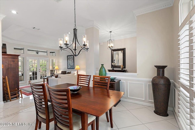 dining room with an inviting chandelier, ornamental molding, french doors, and light tile patterned flooring