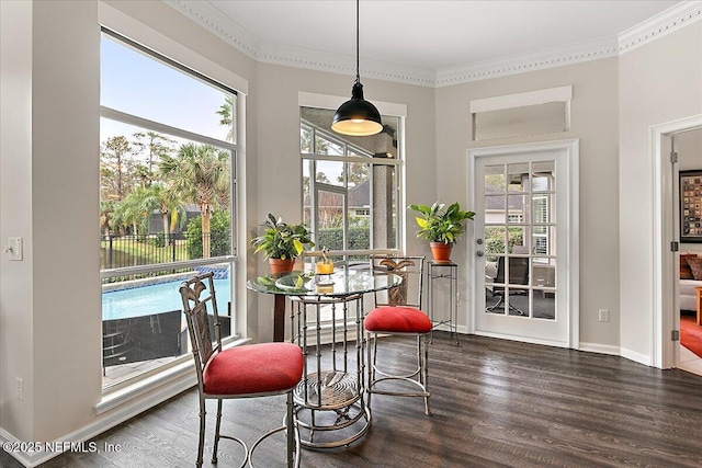 dining space with dark hardwood / wood-style floors, crown molding, and a healthy amount of sunlight