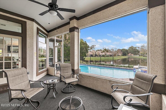 sunroom featuring a water view and ceiling fan