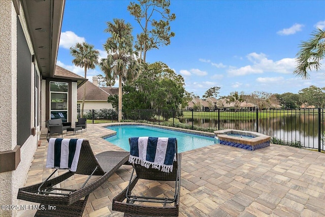 view of pool with an in ground hot tub, a patio area, and a water view