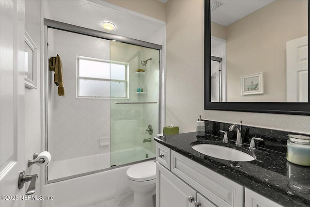 full bathroom featuring vanity, toilet, and bath / shower combo with glass door