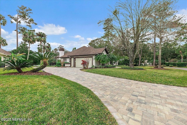 view of front of property with a garage and a front lawn