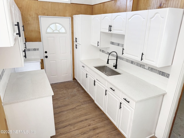 kitchen with hardwood / wood-style flooring, sink, and white cabinetry