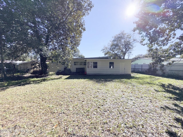 rear view of house featuring a lawn