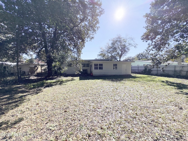 rear view of property with a yard