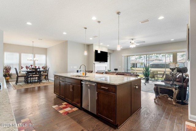 kitchen with dark hardwood / wood-style floors, pendant lighting, dishwasher, an island with sink, and sink