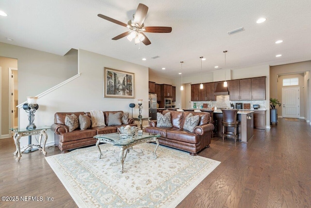 living room featuring ceiling fan, sink, a textured ceiling, and dark hardwood / wood-style flooring