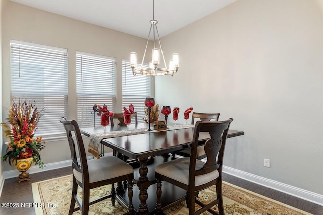 dining space with hardwood / wood-style floors and an inviting chandelier