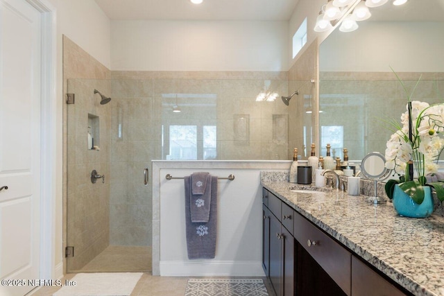 bathroom with walk in shower, vanity, and tile patterned flooring